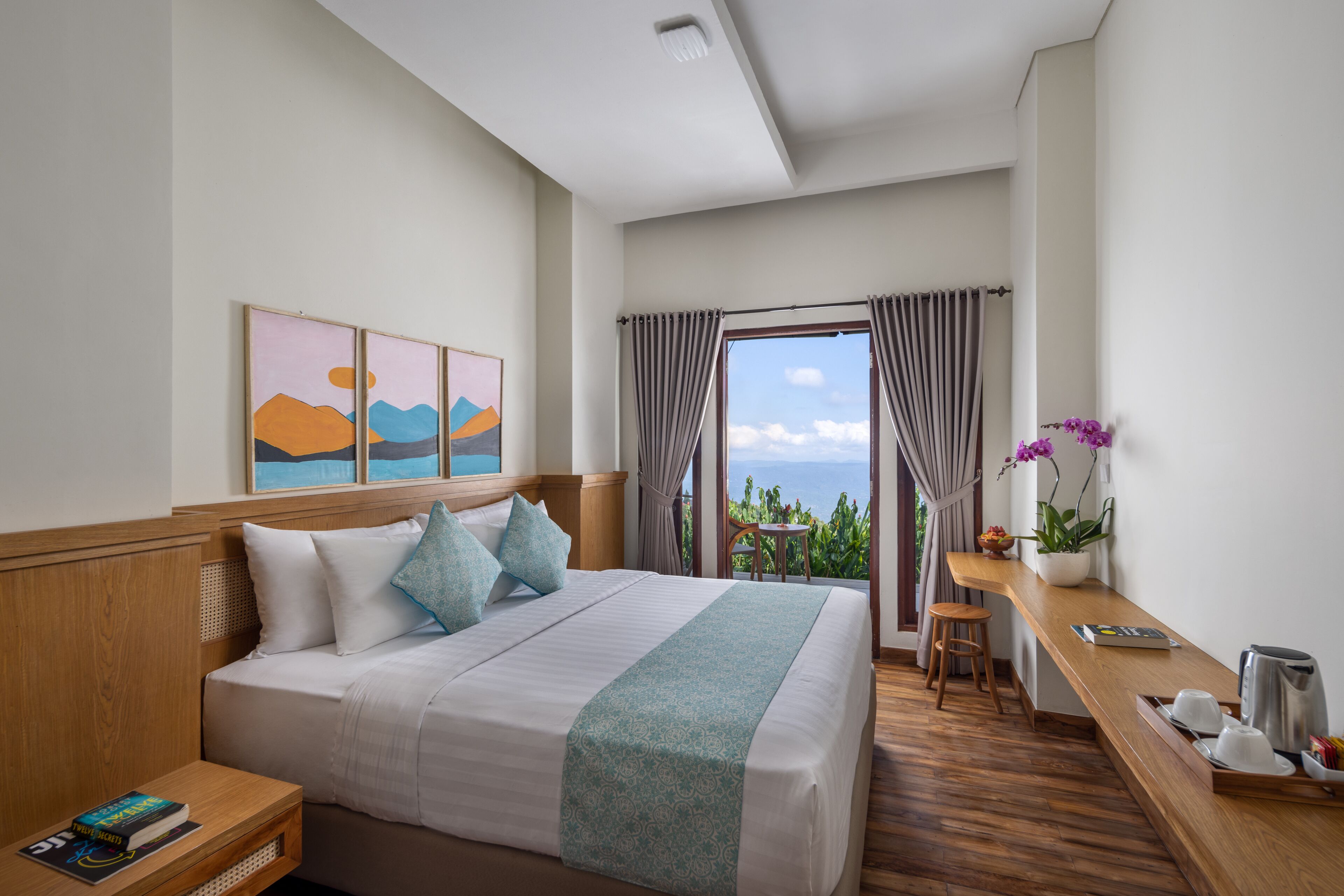 A hotel room with a large bed, a desk, and a view of the ocean.