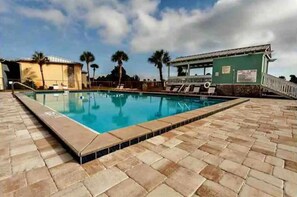 A swimming pool with a tiled deck, a lifeguard stand, and palm trees in the background. - NEW!  Destin Budget Vacation Condo Rental 3 Pools, Lake Access, Sleeps 4. (Destin)