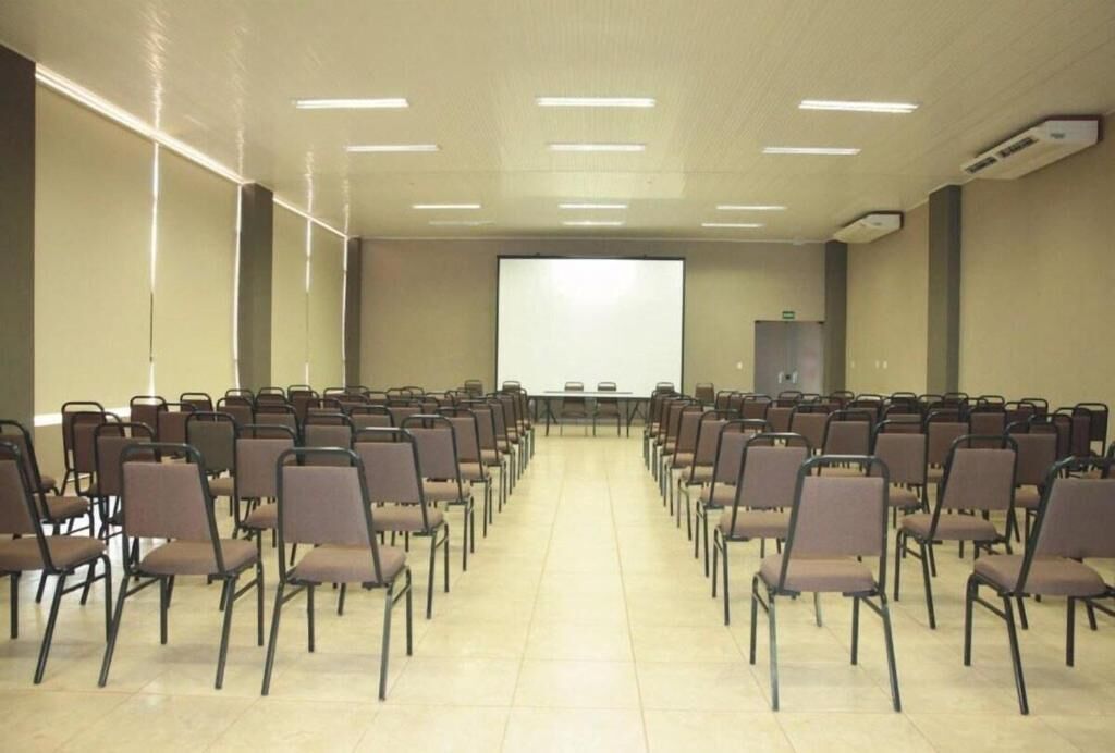 A conference room with rows of chairs facing a projection screen.