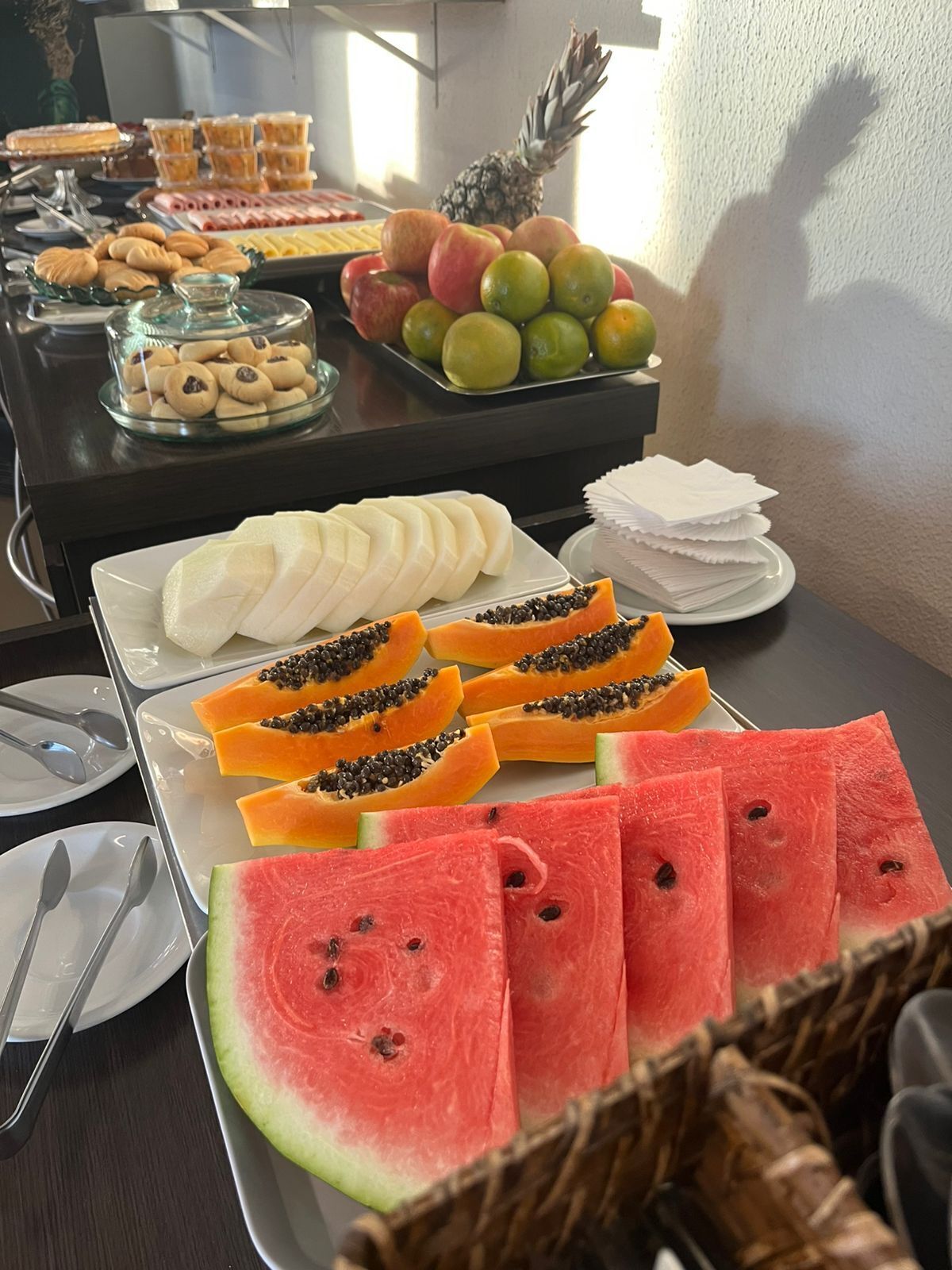 A buffet table with various fruits and pastries.