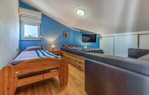 A bedroom with a wooden bed, a sofa, a TV, and a window. - Beach front home in Medulin with WiFi (Medulin)