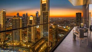 A high-rise building with a view of a cityscape at sunset.