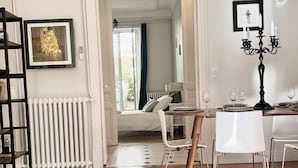 A spacious dining area with a table set for four, a radiator, and a framed picture on the wall.
