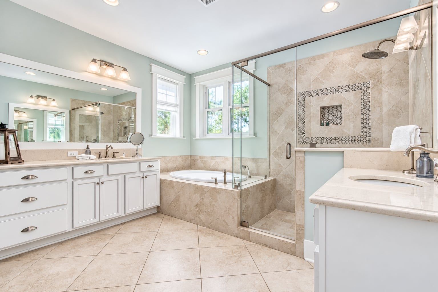 A modern bathroom with a walk-in shower, a freestanding bathtub, and a vanity with a large mirror.