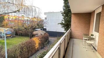 Enjoy a peaceful view from this balcony with seating for two.
