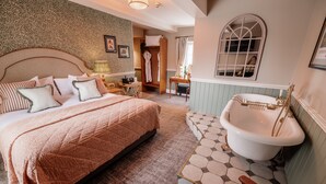 A bedroom with a large bed, a classic clawfoot bathtub, and a walk-in closet. - The Ashford Arms (Bakewell)