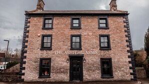 A two-story brick building with black-framed windows and a black door, labeled "THE ASHFORD ARMS". - The Ashford Arms (Bakewell)