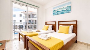 A hotel room with two beds, a balcony, and a painting of waves. - 2BR Apartment with Pool - Poppy by Premier (Paralimni)