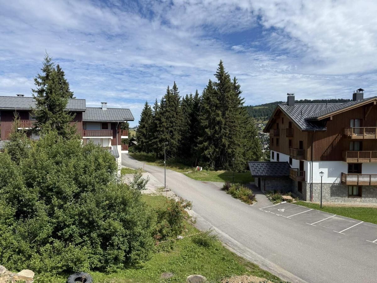 Un quartier résidentiel avec des maisons à deux étages, une route asphaltée et un parking.
