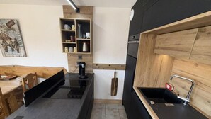 A modern kitchen with a black countertop, wooden cabinets, and a built-in sink.