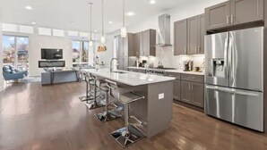 A modern kitchen with a central island, stainless steel appliances, and a large window. - Always A Guest Favorite! Luxe 3 Level Home+ HUGE Rooftop Deck w/TV, fireplace! (Berry Hill)