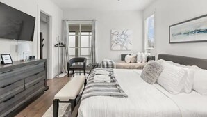 A modern bedroom with a large bed, a bench, a dresser, and a ceiling fan. - Always A Guest Favorite! Luxe 3 Level Home+ HUGE Rooftop Deck w/TV, fireplace! (Berry Hill)
