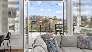A modern living room with a sofa, chairs, and a dining area. - Always A Guest Favorite! Luxe 3 Level Home+ HUGE Rooftop Deck w/TV, fireplace! (Berry Hill)