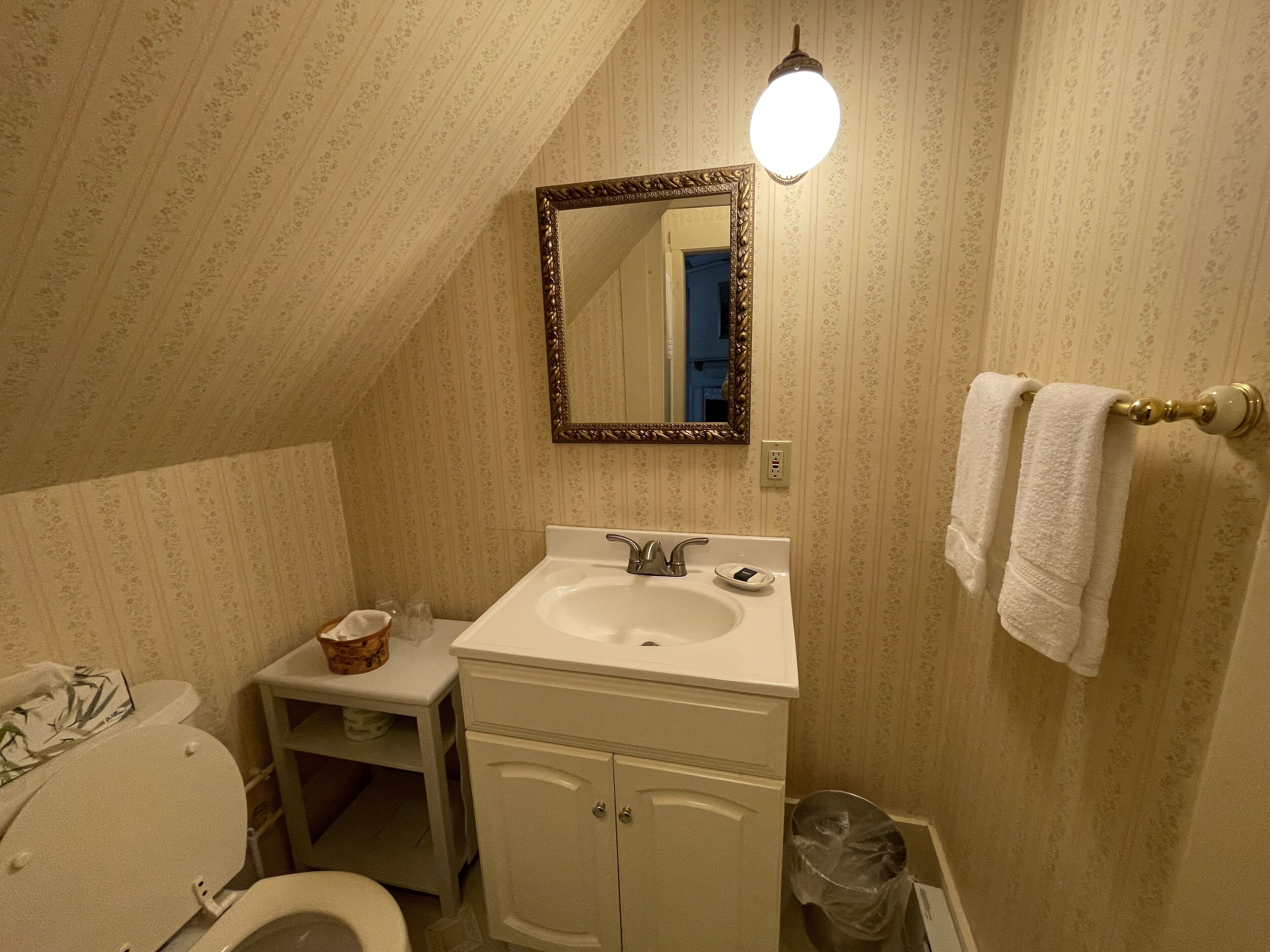 A bathroom with a white sink, a mirror, and a towel rack.