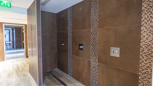 A modern elevator interior with metallic walls and a patterned tile design.