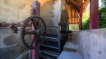 A rustic wooden structure with a metal door and a staircase leading to a higher level.
