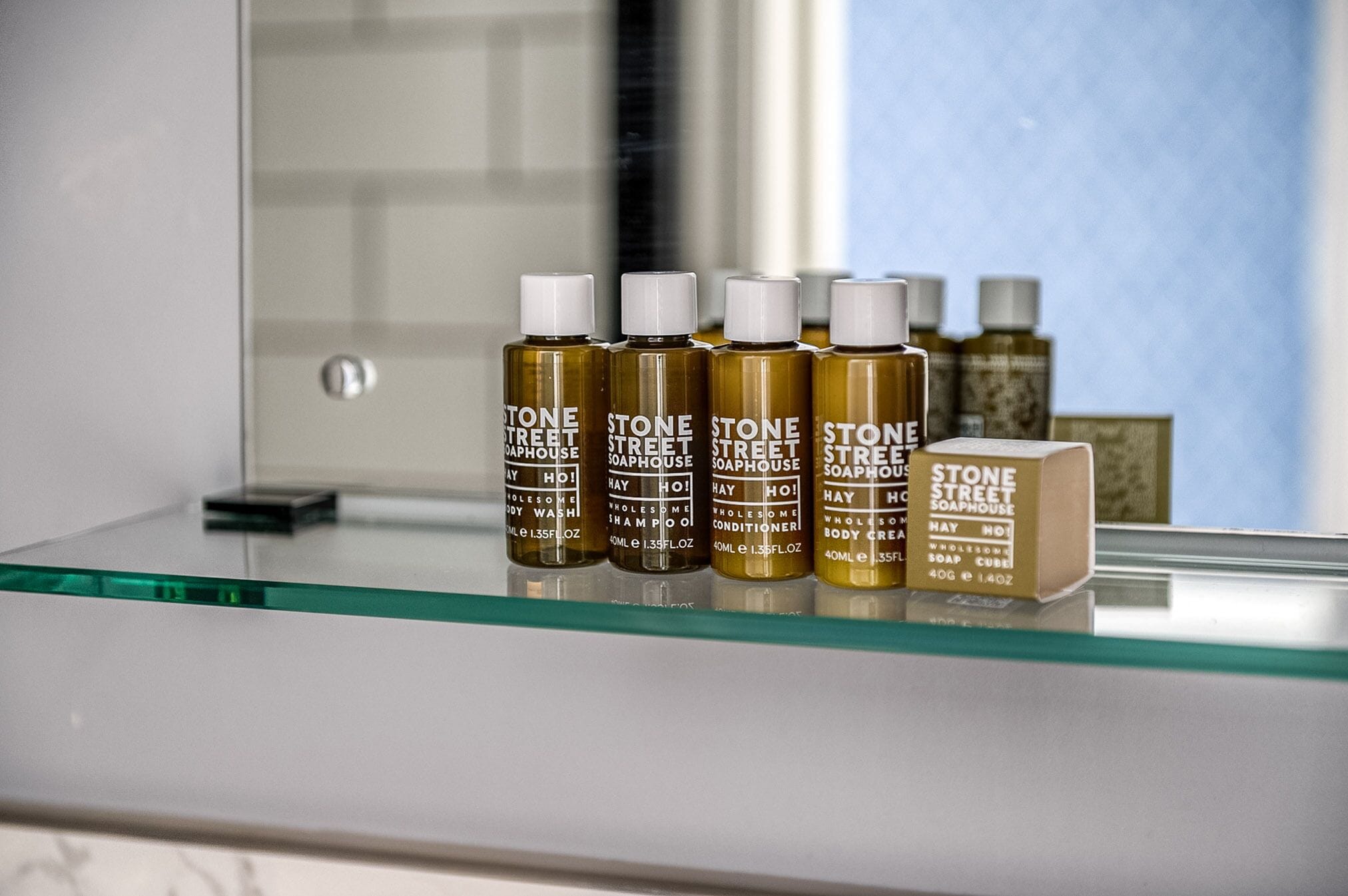 Une étagère de salle de bain avec des bouteilles de savon et de gel douche de la marque Stone Street.