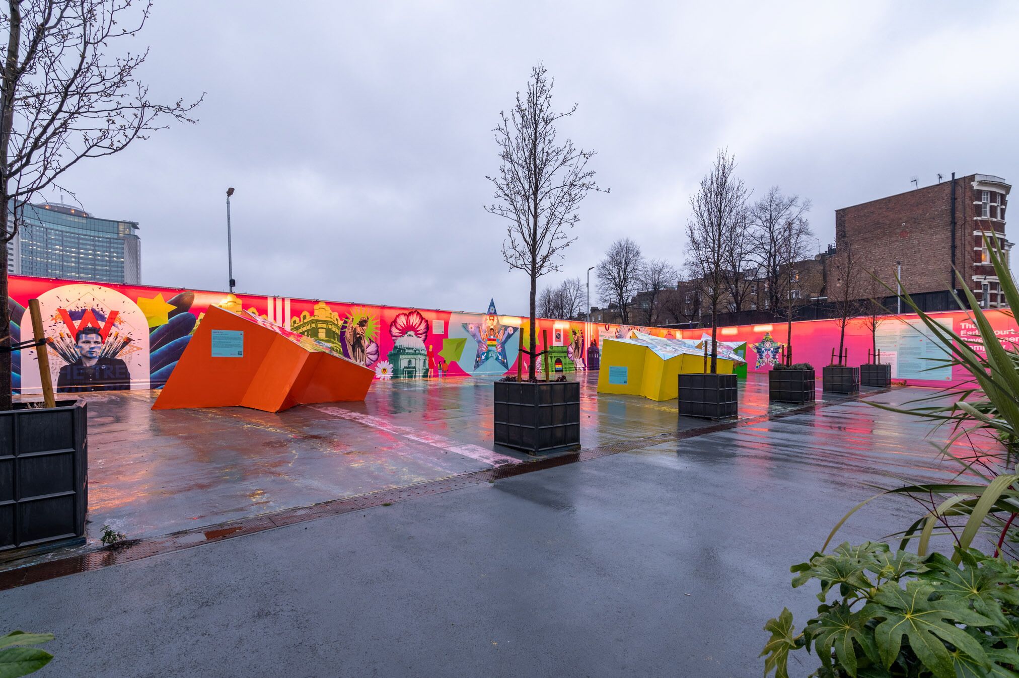 Un espace extérieur abrité, agrémenté de peintures murales colorées et de structures géométriques.