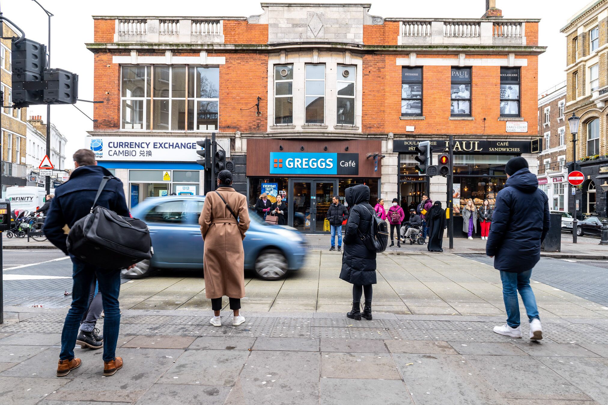 Une scène de rue avec un café appelé Greggs et un bureau de change.