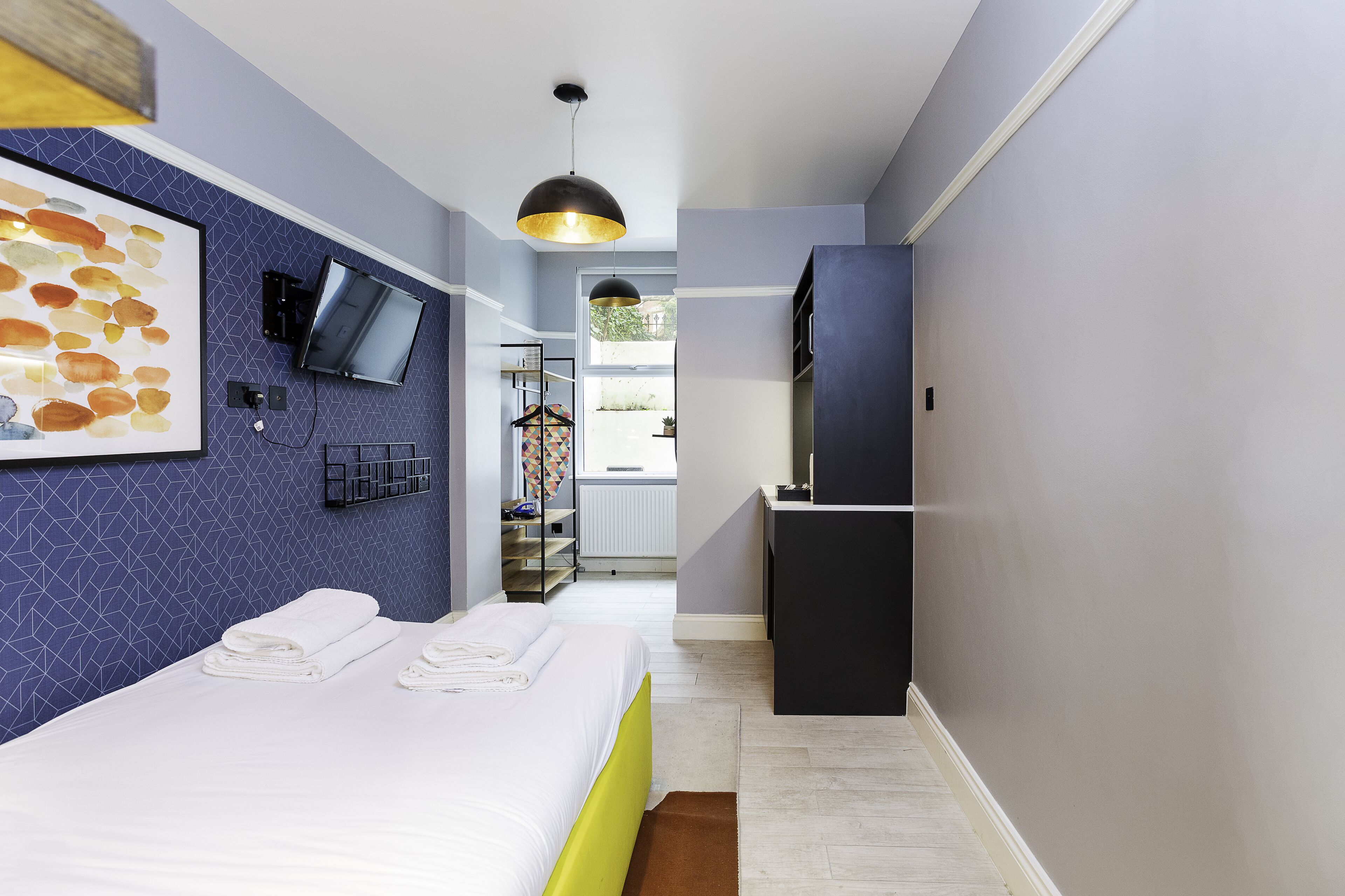 Habitació d'hotel moderna amb un llit, una televisió de pantalla plana, un escriptori i vista a l'exterior.