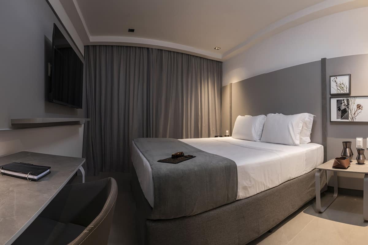 Una habitación de hotel moderna con una cama, un escritorio y una silla.