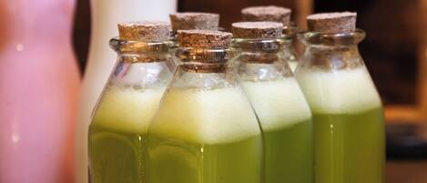 Botellas verdes en fila con tapones de corcho sobre una encimera.