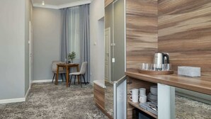 A compact hotel room with a dining area, a built-in kitchen with a coffee maker, and a small seating area. - Cozy Studio in the Center | 1.3 km from the Main Square (Kraków)