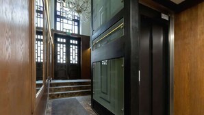 A modern elevator with a glass panel and a wooden interior. - Cozy Studio in the Center | 1.3 km from the Main Square (Kraków)
