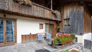 A rustic wooden building with stone flooring, wooden benches, and flower boxes. - Casa Lacedel 1 on Ski slopes (Cortina d´Ampezzo)