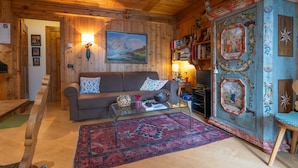 A cozy wooden interior with a sofa, a coffee table, and a decorative cabinet. - Casa Lacedel 1 on Ski slopes (Cortina d´Ampezzo)