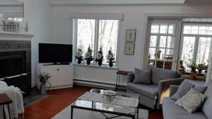 A living room with a fireplace, a television, a sofa, and a coffee table.