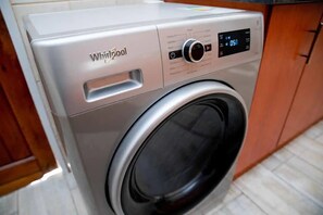 A Whirlpool washing machine with a digital control panel and a front-loading door. - Chic Modern House on Neasden - 2085 (Bulawayo)