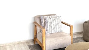 A room with a grey sofa, a round coffee table, and a large abstract painting on the wall. - Chic Modern House on Neasden - 2085 (Bulawayo)