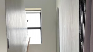 A staircase with a handrail and a window at the top. - Chic Modern House on Neasden - 2085 (Bulawayo)