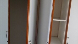 A room with a wardrobe featuring two doors and a built-in shelf. - Neat guest suite with office corner - 2101 (Harare)