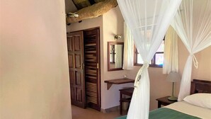 A room with a bed, a desk, a chair, and a wardrobe.