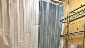 Une salle de bain avec une baignoire, des toilettes et un rideau de douche.