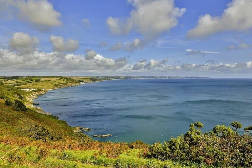 Paisaje costero con colinas ondulantes y una vista despejada del mar.