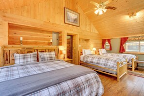 A cozy wooden cabin room with two beds, a ceiling fan, and a framed picture on the wall. - Creekside Silver Gate Getaway w/ Fireplace! (Silver Gate)
