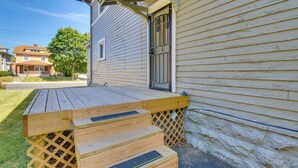 A wooden deck with steps leading to a house with a metal gate and a welcome sign. - Sunny + Spacious Dayton Condo ~ 1 Mi to Downtown! (Dayton)