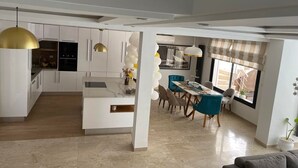 Una cocina moderna con armarios blancos, una isla central e iluminación colgante.