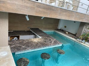 Una piscina con un suelo de piedra y una pequeña cascada.