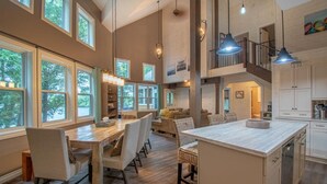 A spacious kitchen with a central island, large windows, and a mezzanine level. - Muskoka Serenity - Four Bedroom Cottage, Sleeps 8 (Torrance)