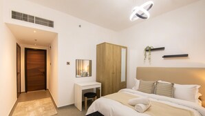 Ein modernes Schlafzimmer mit Bett, Nachttisch, Schreibtisch, Kleiderschrank und Spiegel.
