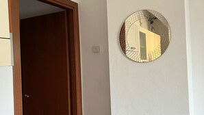 A room with a wooden door, a tiled floor, and a wall-mounted round mirror with a mosaic border. - Lakeview Lakecomo 4seasons, Terrace, 30m to Lake! (Acquaseria)