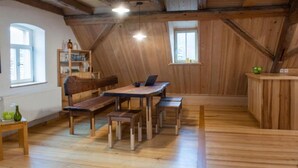 A wooden interior with a dining table, benches, and a kitchen area. - Apartment Walnut (Oberscheinfeld)