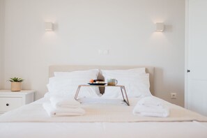 Comfortable retreat with a large bed, two nightstands, and potted plants.