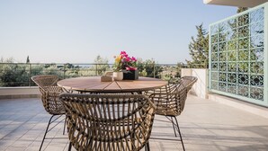 A round wooden table with wicker chairs on a balcony with a view of the sea. - Locanda villas Lefkada B (Lefkada)