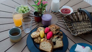 A breakfast setup by a poolside with a variety of food items, drinks, and a small plant. - Locanda Villa Lefkada C (Lefkada)