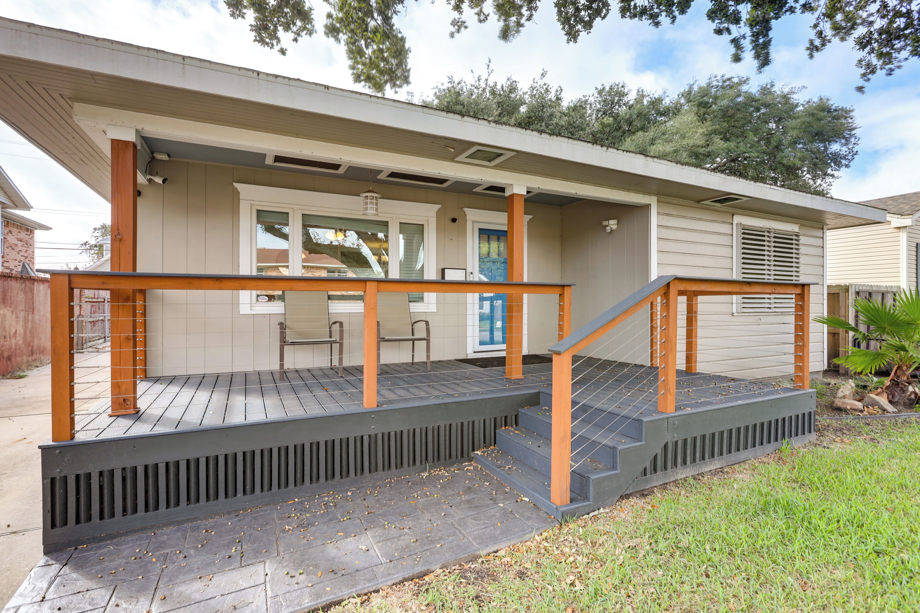 A residential house with a covered porch, a staircase, and a small outdoor seating area.
